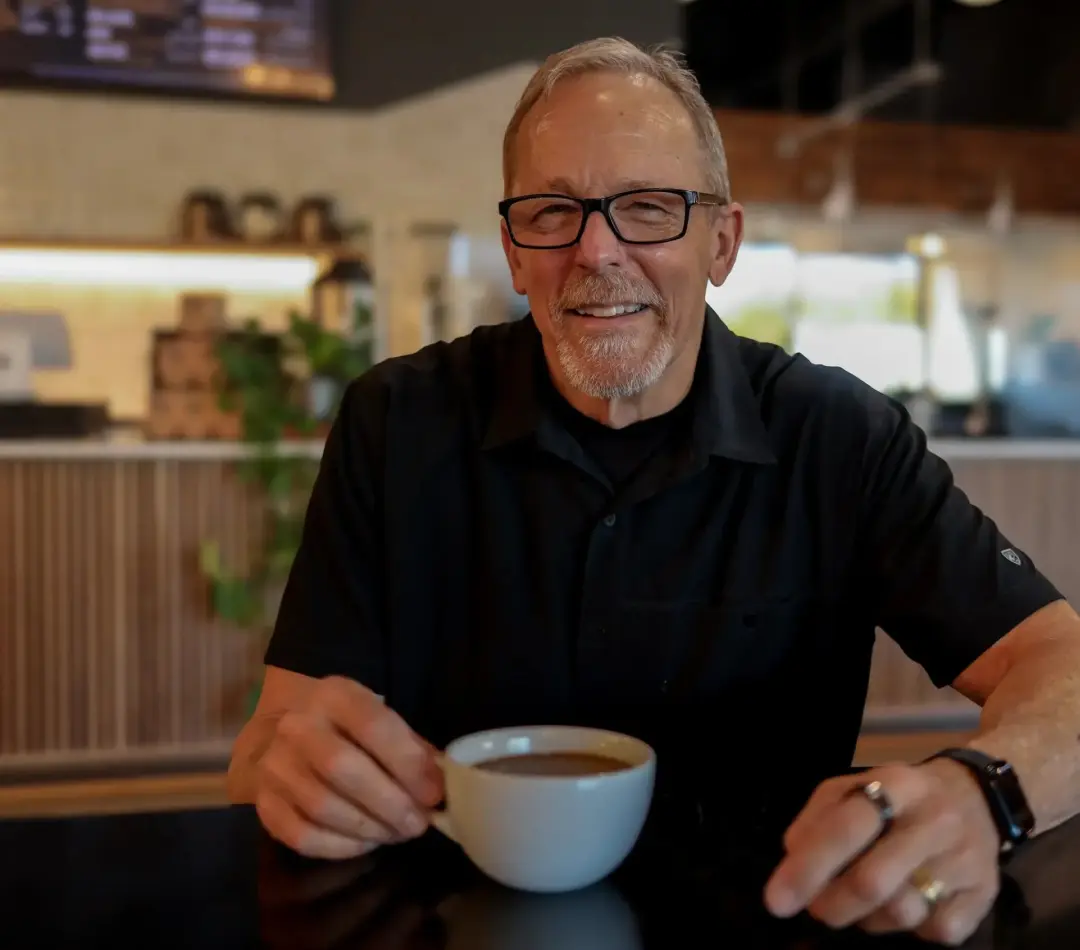 Bill Griffin sitting with a coffee in a black shirt